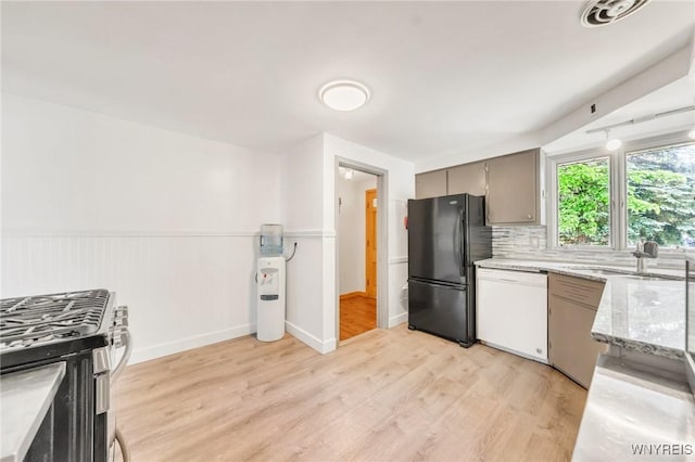 36 Lennox Ave, Amherst, NY 14226 - kitchen with freestanding refrigerator, white dishwasher, stainless steel range with gas stovetop, light wood-type flooring, and tasteful backsplash
