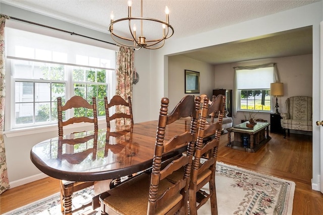158 Pine Valley Dr, Greece, NY 14626 - dining space with a chandelier, healthy amount of natural light, wood finished floors, and a textured ceiling