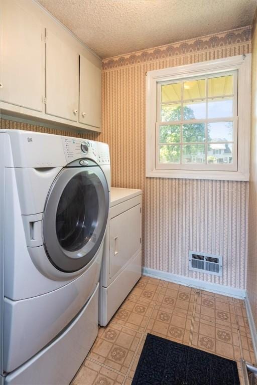 158 Pine Valley Dr, Greece, NY 14626 - laundry room with wallpapered walls, washing machine and clothes dryer, cabinet space, a textured ceiling, and light flooring