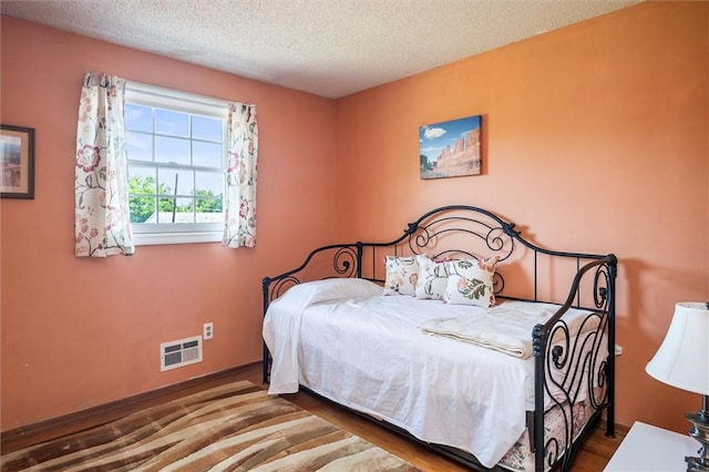 158 Pine Valley Dr, Greece, NY 14626 - bedroom featuring a textured ceiling and wood finished floors