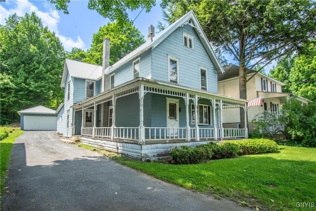 14309 Maple St, Diana, NY 13648 - victorian house featuring a porch, a chimney, an outdoor structure, a detached garage, and a front lawn