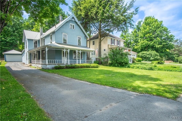 14309 Maple St, Diana, NY 13648 - victorian-style house featuring a porch, an outbuilding, a front lawn, and a detached garage