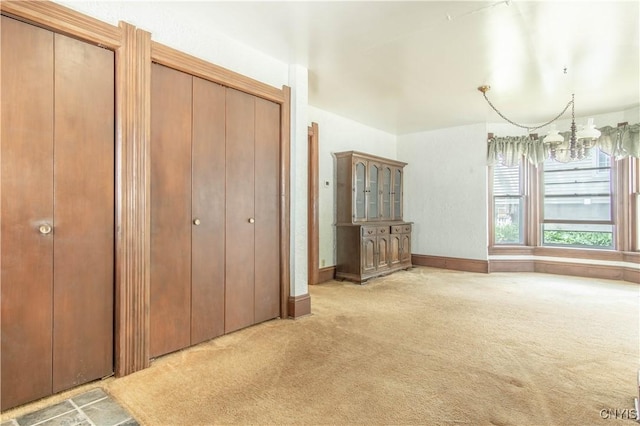 14309 Maple St, Diana, NY 13648 - unfurnished bedroom featuring a chandelier, carpet flooring, and multiple closets