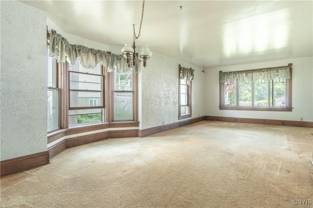 14309 Maple St, Diana, NY 13648 - unfurnished dining area featuring a chandelier, a textured wall, and carpet flooring