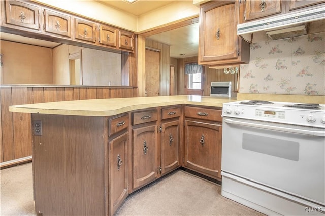 14309 Maple St, Diana, NY 13648 - kitchen with electric range, under cabinet range hood, light colored carpet, a peninsula, and light countertops