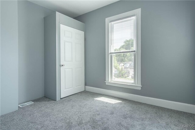 807 Bingham Ave, Watertown City, NY 13601 - unfurnished bedroom featuring multiple windows and carpet
