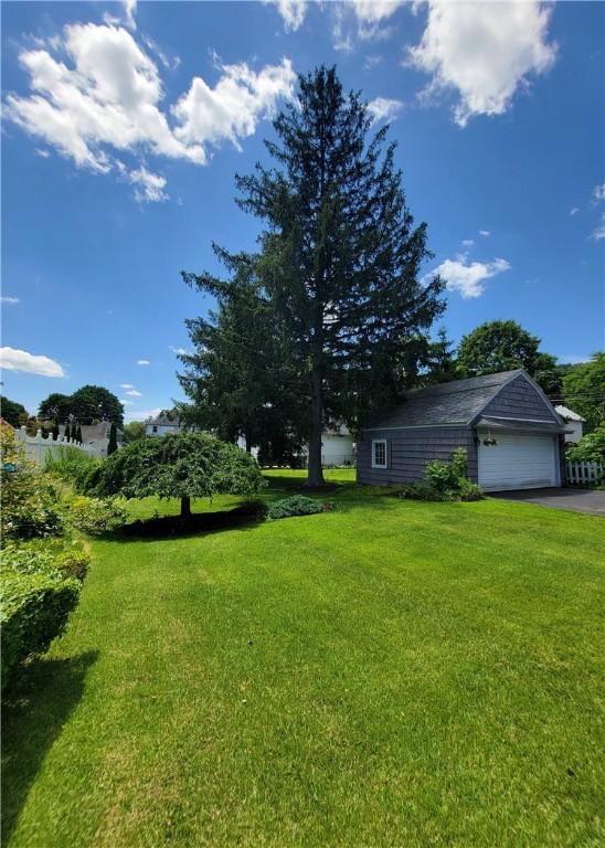 25 Francis Ave, Norwich, NY 13815 - view of green lawn with a detached garage and asphalt driveway