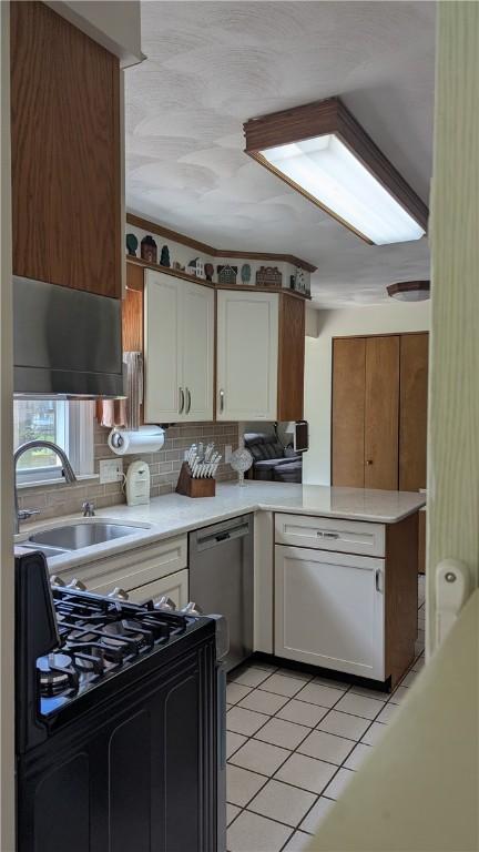 818 Tinker Tavern Rd, Webster, NY 14580 - kitchen featuring gas range oven, stainless steel dishwasher, light countertops, light tile patterned floors, and white cabinetry