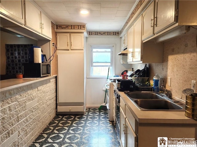 515 Newland Ave, Jamestown, NY 14701 - kitchen featuring stainless steel microwave, under cabinet range hood, dark floors, and light countertops