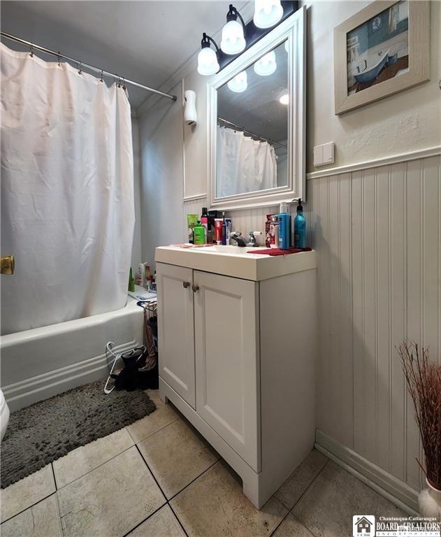 515 Newland Ave, Jamestown, NY 14701 - full bath featuring vanity, shower / tub combo, tile patterned floors, and a wainscoted wall