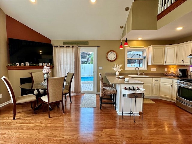 187 Seaward Ave, Bradford-City, PA 16701 - kitchen with stainless steel gas stove, white cabinetry, a kitchen breakfast bar, light wood-style floors, and a peninsula