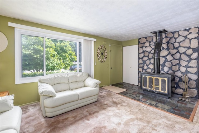 244 Wildflower Dr, Henrietta, NY 14623 - carpeted living room featuring a wood stove and a textured ceiling