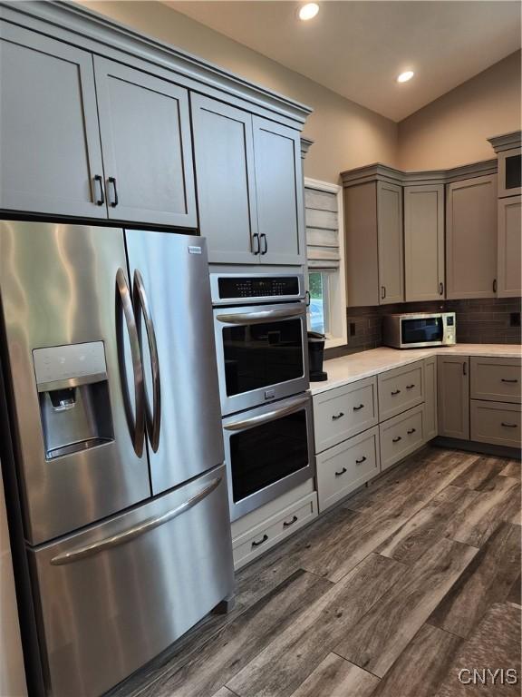 1683 Song Mountain Rd, Preble, NY 13141 - kitchen with appliances with stainless steel finishes, gray cabinetry, dark wood-style floors, light countertops, and decorative backsplash