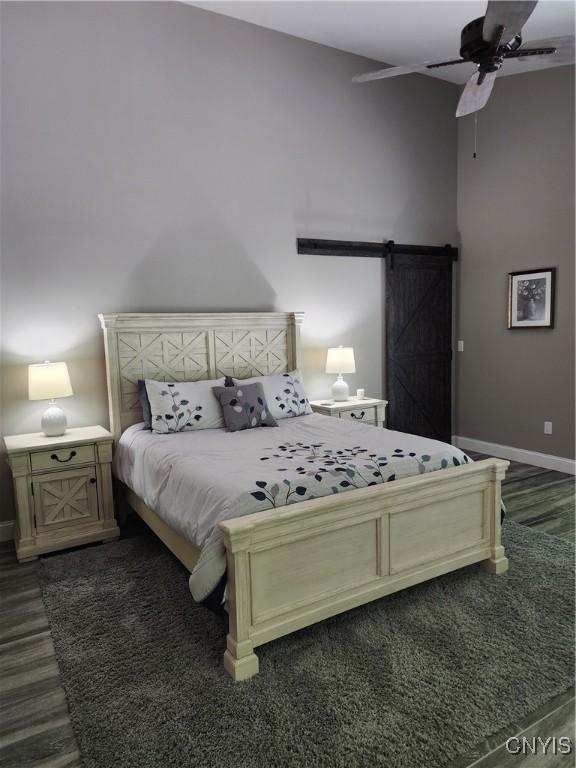 1683 Song Mountain Rd, Preble, NY 13141 - bedroom with a barn door, dark wood-style floors, and ceiling fan