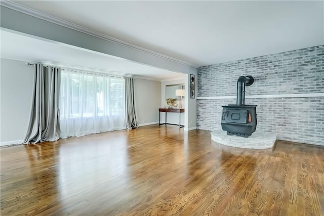 138 Cherry Rd, Rochester, NY 14612 - unfurnished living room with brick wall, a wood stove, ornamental molding, and wood finished floors