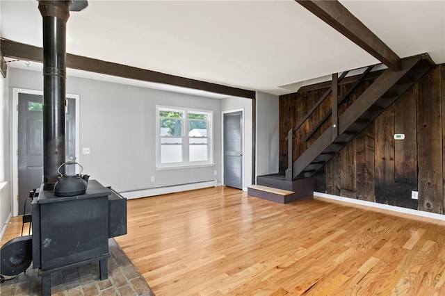 5808 W Wautoma Beach Rd, Hamlin, NY 14468 - living room featuring baseboard heating, a wood stove, stairs, wood finished floors, and beamed ceiling