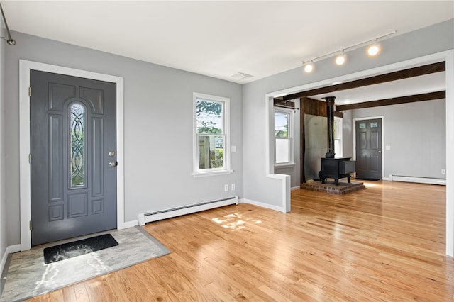 5808 W Wautoma Beach Rd, Hamlin, NY 14468 - foyer with a baseboard heating unit, a wood stove, light wood-style floors, and track lighting