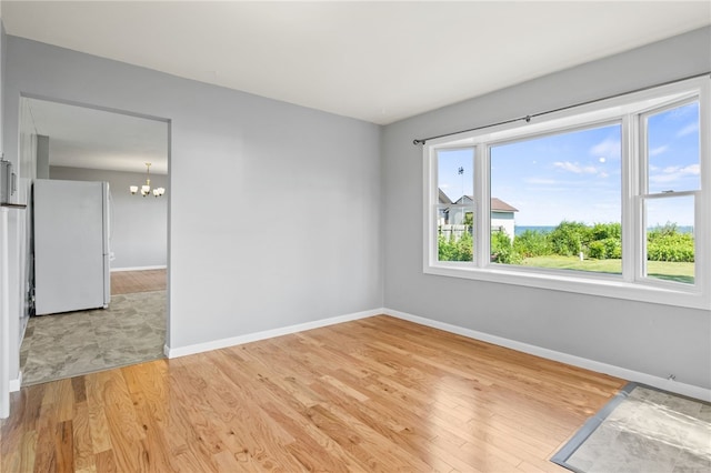 5808 W Wautoma Beach Rd, Hamlin, NY 14468 - unfurnished room featuring a chandelier and light wood-type flooring