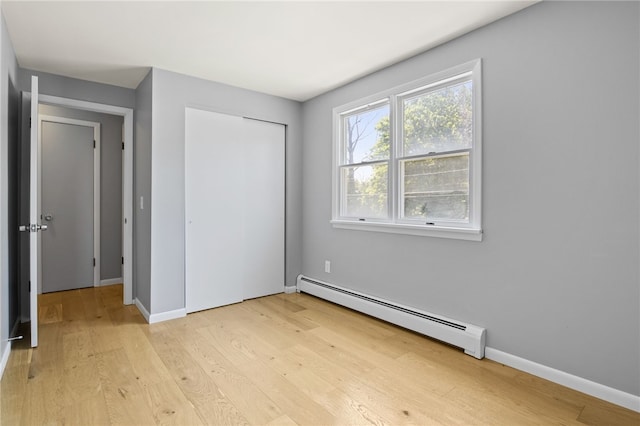 5808 W Wautoma Beach Rd, Hamlin, NY 14468 - unfurnished bedroom featuring a baseboard radiator, light wood finished floors, and a closet