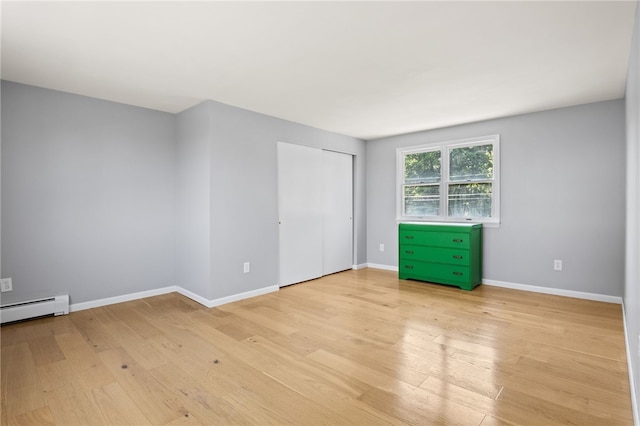 5808 W Wautoma Beach Rd, Hamlin, NY 14468 - unfurnished bedroom featuring light wood finished floors, a baseboard heating unit, and a closet