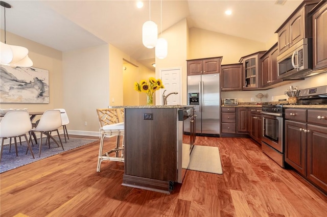 246 Maryview Dr, Penfield, NY 14580 - kitchen with stainless steel appliances, a breakfast bar, glass insert cabinets, wood finished floors, and light stone countertops