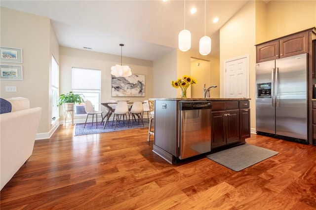 246 Maryview Dr, Penfield, NY 14580 - kitchen with stainless steel appliances, an island with sink, dark wood-style flooring, pendant lighting, and stone countertops