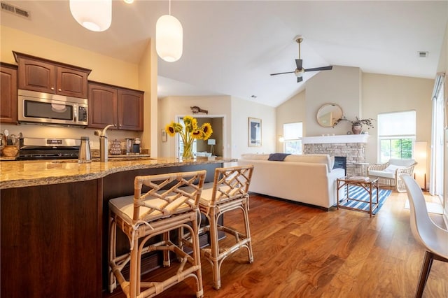 246 Maryview Dr, Penfield, NY 14580 - kitchen with stainless steel appliances, light stone countertops, a ceiling fan, a breakfast bar area, and dark wood finished floors