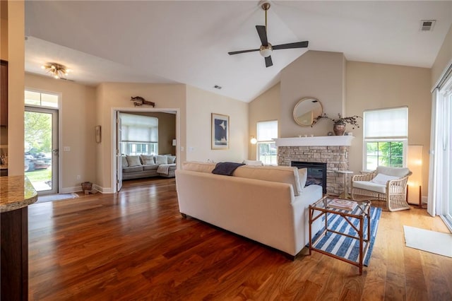 246 Maryview Dr, Penfield, NY 14580 - living room with a stone fireplace, wood finished floors, healthy amount of natural light, a ceiling fan, and high vaulted ceiling