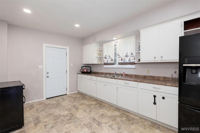493 S Ogden St Unit E, Buffalo, NY 14206 - kitchen with open shelves, black refrigerator with ice dispenser, dark countertops, white cabinetry, and stone finish flooring