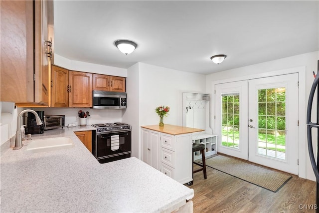 1848 Otisco Valley Rd, Otisco, NY 13110 - kitchen with stove, stainless steel microwave, light countertops, french doors, and wood finished floors