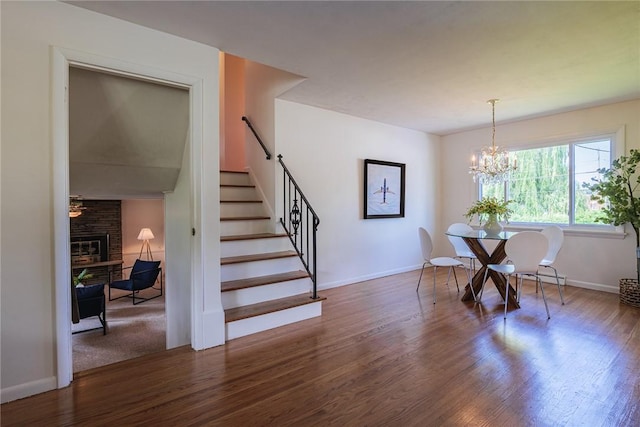 164 Queens Ln, Irondequoit, NY 14617 - dining area featuring wood finished floors, stairs, a fireplace, and a chandelier