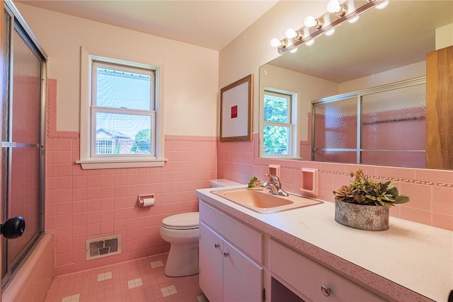 164 Queens Ln, Irondequoit, NY 14617 - full bath with vanity, tile patterned flooring, tile walls, wainscoting, and combined bath / shower with glass door