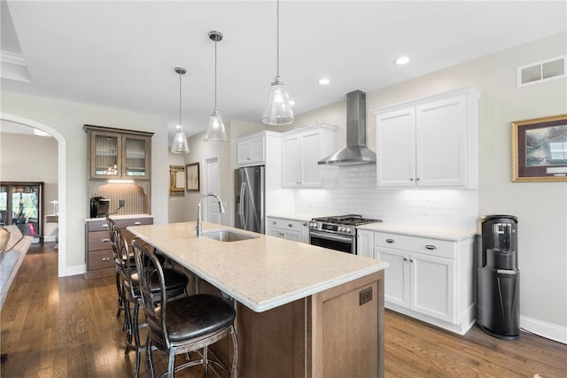 905 Pathway Ln, Webster, NY 14580 - kitchen featuring wall chimney range hood, stainless steel appliances, arched walkways, dark wood-style floors, and recessed lighting