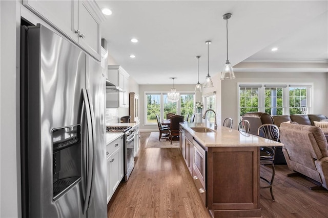 905 Pathway Ln, Webster, NY 14580 - kitchen featuring stainless steel appliances, open floor plan, a breakfast bar, dark wood-type flooring, and white cabinets