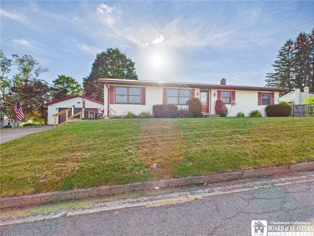 407 N Clark St, Olean, NY 14760 - ranch-style home featuring asphalt driveway, a front yard, a garage, a chimney, and an outbuilding