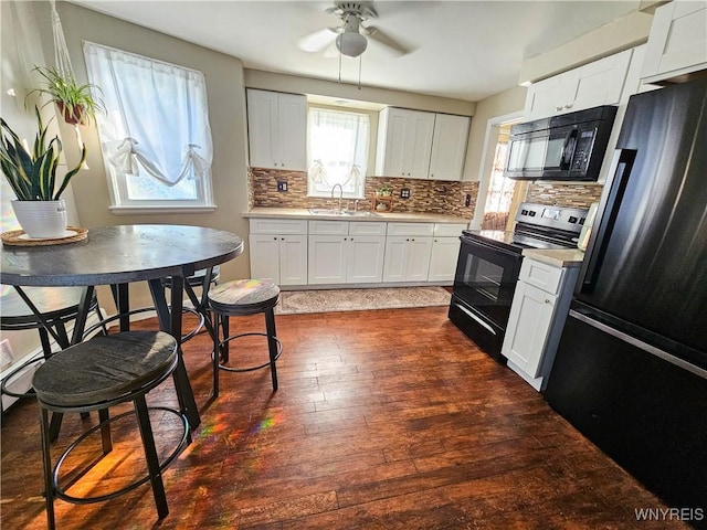 218 Edward St, North Tonawanda, NY 14120 - kitchen featuring black appliances, light countertops, dark wood finished floors, tasteful backsplash, and a ceiling fan