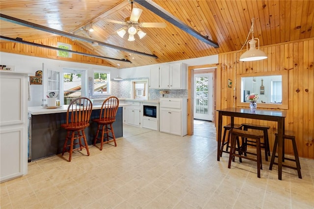1753 Log Cabin Rd, Torrey, NY 14527 - kitchen featuring built in microwave, wooden ceiling, white cabinets, light countertops, and backsplash