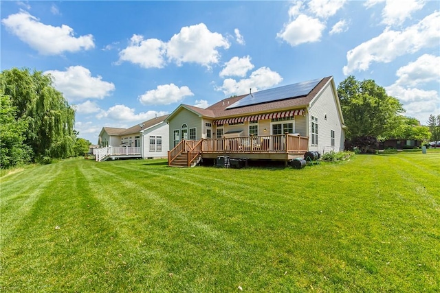 801 Surrey Hill Way, Henrietta, NY 14623 - back of property with a wooden deck, roof mounted solar panels, and a lawn