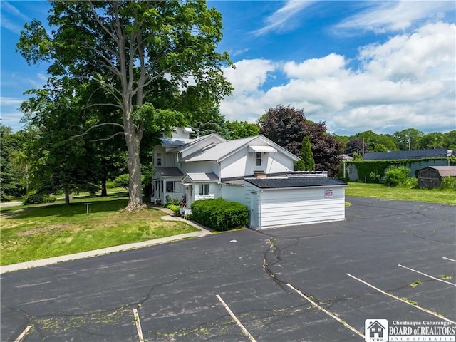 12 Central Ave, Portland, NY 14716 - view of front of home featuring uncovered parking, a front yard, view of scattered trees, and a metal roof