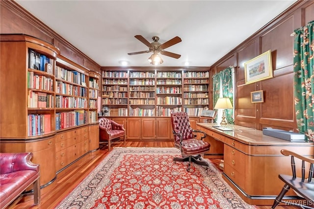9555 The Maples, Clarence, NY 14031 - office with wall of books, ornamental molding, light wood-style flooring, a ceiling fan, and built in shelves