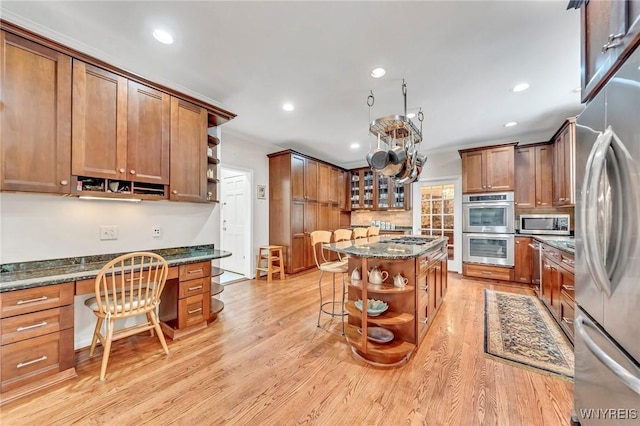 9555 The Maples, Clarence, NY 14031 - kitchen featuring open shelves, appliances with stainless steel finishes, built in study area, brown cabinetry, and recessed lighting