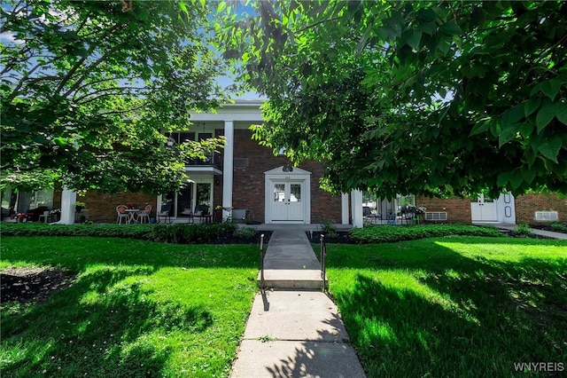335 S Cayuga Rd Unit B, Amherst, NY 14221 - view of front facade featuring brick siding, a front lawn, and covered porch