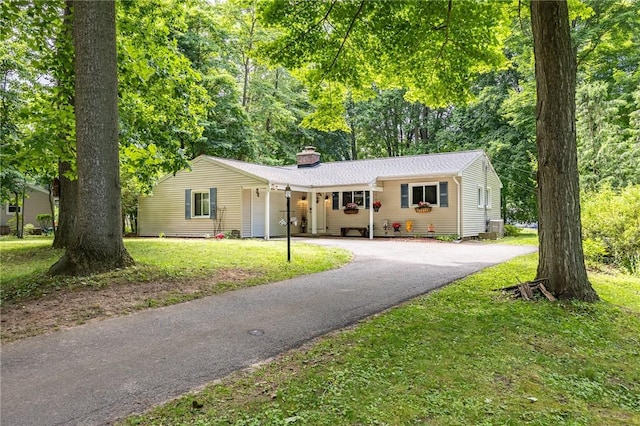 28 Crossfield Rd, Perinton, NY 14450 - ranch-style home featuring driveway, a chimney, a front yard, and a garage