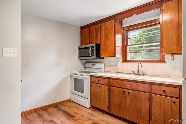 44 Deuro Dr, Niagara Falls, NY 14304 - kitchen featuring white electric range, stainless steel microwave, light wood-type flooring, decorative backsplash, and brown cabinets