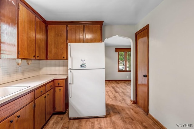 44 Deuro Dr, Niagara Falls, NY 14304 - kitchen with freestanding refrigerator, arched walkways, light wood-style flooring, and tasteful backsplash