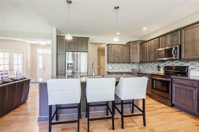 996 Summer Creek Ln, Webster, NY 14580 - kitchen with stainless steel appliances, dark brown cabinets, tasteful backsplash, light wood-style flooring, and light stone countertops