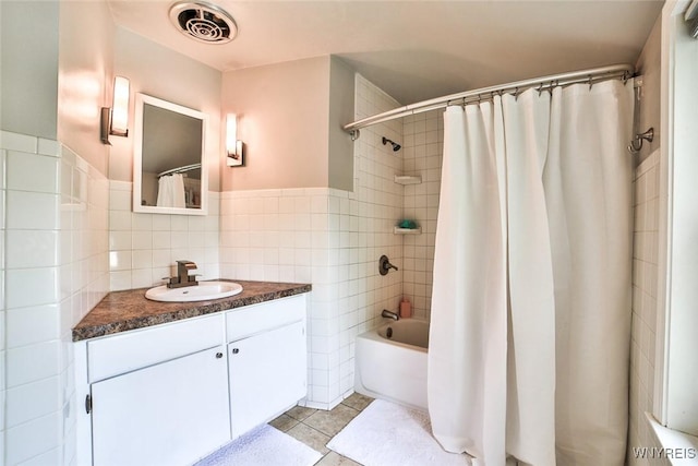 170 Sargent Dr, Amherst, NY 14226 - bathroom with tile walls, vanity, tile patterned floors, shower / bath combo with shower curtain, and a wainscoted wall