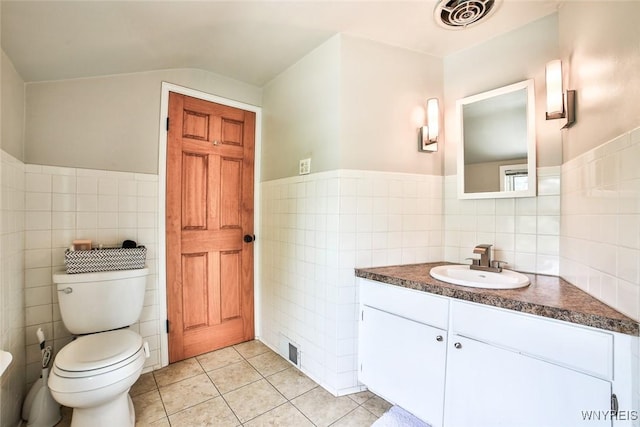 170 Sargent Dr, Amherst, NY 14226 - bathroom featuring tile walls, vanity, tile patterned floors, a wainscoted wall, and lofted ceiling
