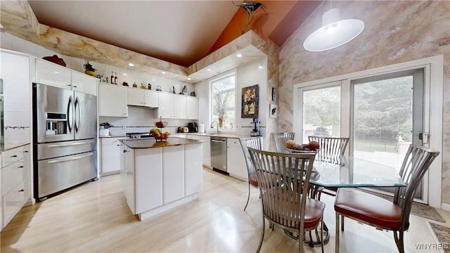 6097 Wellesley Cmn, Clarence, NY 14051 - kitchen featuring stainless steel appliances, a kitchen island, white cabinetry, light wood-style flooring, and pendant lighting