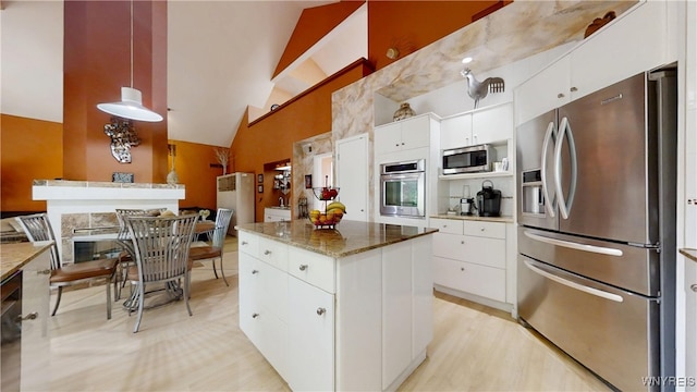 6097 Wellesley Cmn, Clarence, NY 14051 - kitchen featuring appliances with stainless steel finishes, a kitchen island, high vaulted ceiling, white cabinets, and pendant lighting